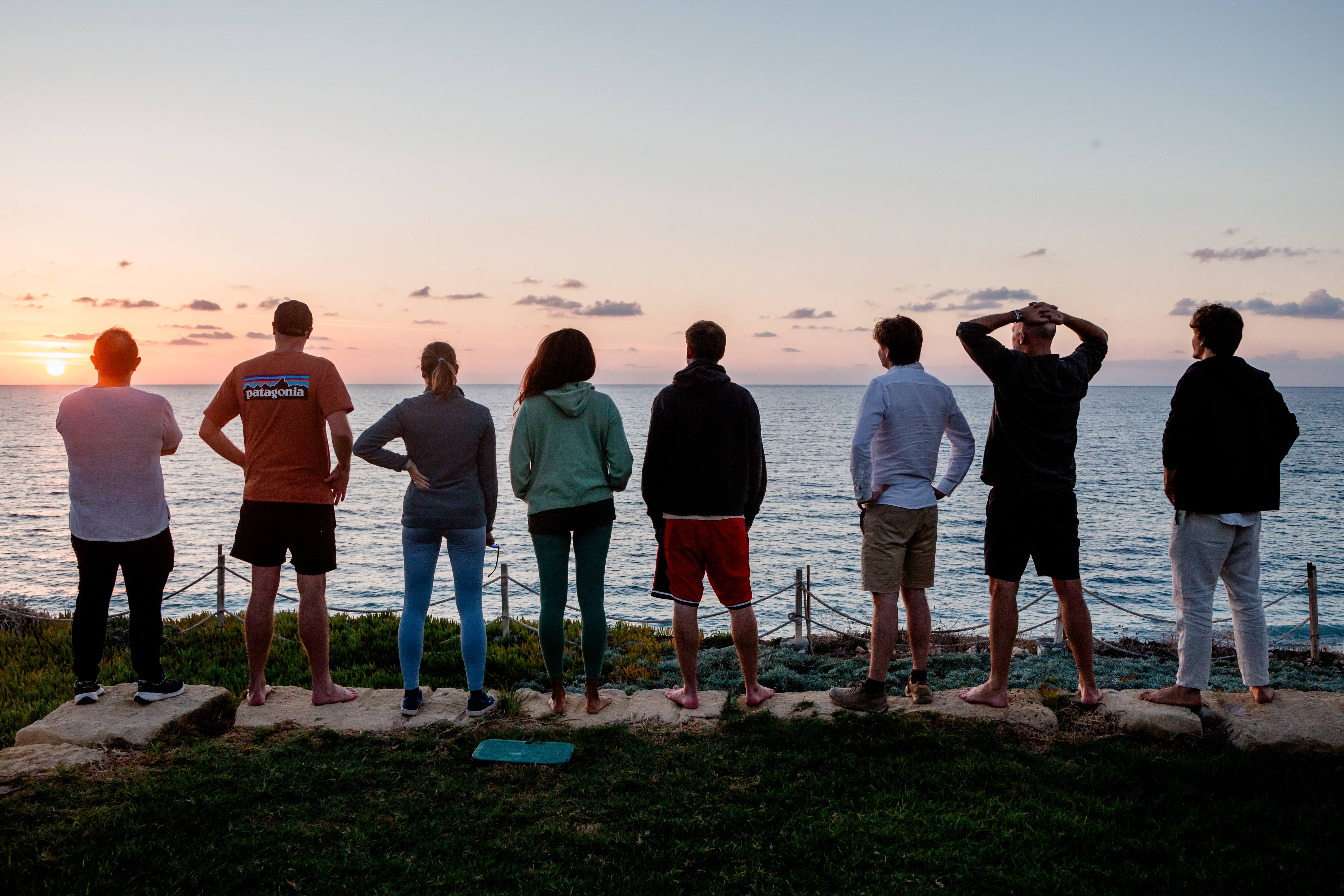 TripLeaders watching sunset together by the sea